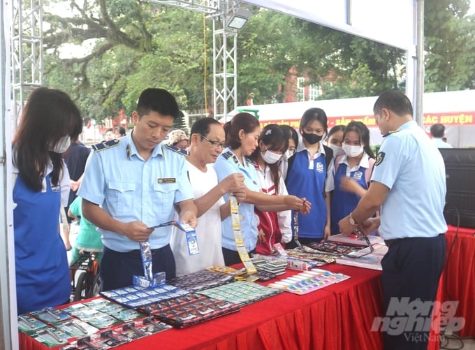 Lực lượng chức năng tỉnh Hà Giang hướng dẫn người dân cách phân biệt hàng giả, hàng thật. Ảnh: Đào Thanh.