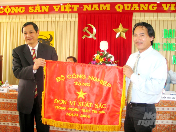 Năm 2004, ông Lê Quốc Phong - Tổng Giám đốc Công ty CP Phân bón Bình Điền (áo trắng) vinh dự đón nhận cờ Đơn vị xuất sắc trong phong trào thi đua của Bộ Công nghiệp do ông Đỗ Duy Phi - Tổng Giám đốc Tập đoàn Hóa chất Việt Nam trao tặng. Ảnh: Ngọc Vân.