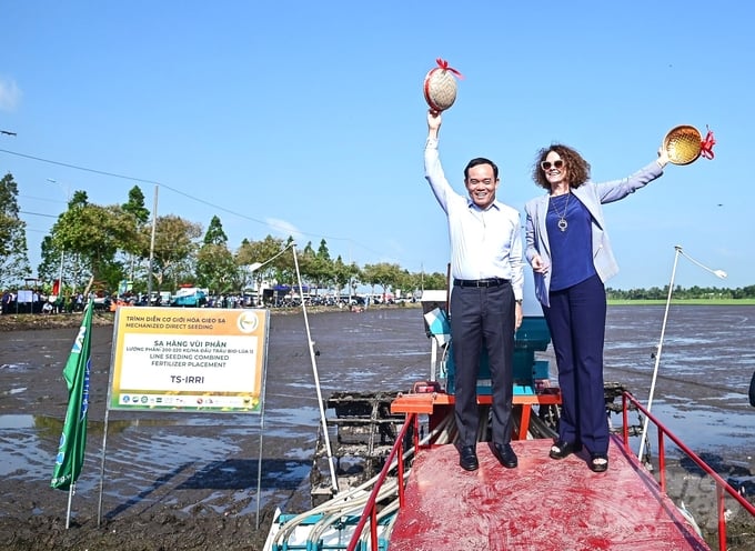 Phó Thủ tướng Chính phủ Trần Lưu Quang và bà Carolyn Turk, Giám đốc Quốc gia Ngân hàng Thế giới tại Việt Nam thực hiện nghi thức đổ lúa giống vào các máy sạ cụm, trước khi tiến hành trình diễn trên đồng ruộng. Ảnh: Trung Chánh.