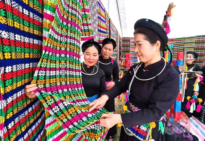 Chị Ngô Thị Phin (ngoài cùng bên phải) hướng dẫn các thành viên trong Tổ thêu dệt thổ cẩm các đường hoa văn tinh xảo. Ảnh: Đào Thanh.