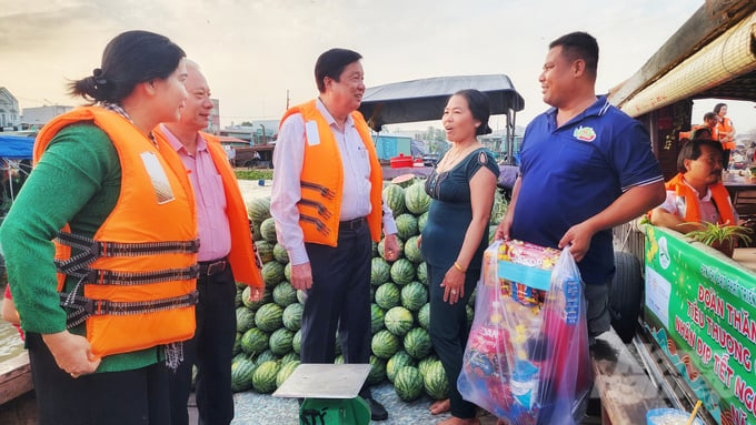 Ông Phạm Văn Hiểu, Phó Bí thư Thường trực Thành uỷ, Chủ tịch HĐND TP Cần Thơ (giữa) tìm hiểu về hoạt động mua bán nông sản dịp cuối năm của tiểu thương tại chợ nổi Cái Răng. Đồng thời tặng quà, động viên tinh thần và mong muốn bà con tiếp tục gắn bó với chợ nổi trong năm mới.