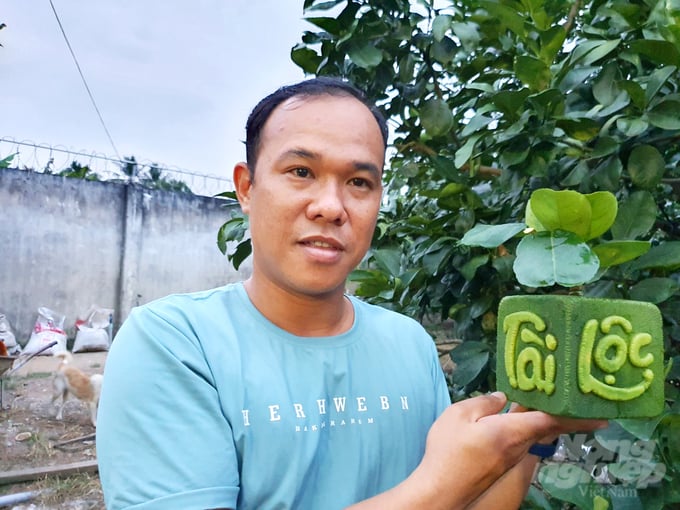 Anh Huỳnh Thanh Tâm, ở xã  An Khánh, huyện Châu Thành - Bến Tre bên sản phẩm bưởi tạo hình Tài Lộc phục vụ cho người dân chưng Tết trong gia đình. Ảnh: Lê Hoàng Vũ.